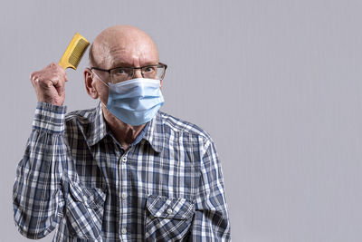 Portrait of man wearing mask against gray background