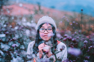 Portrait of woman against plants during winter