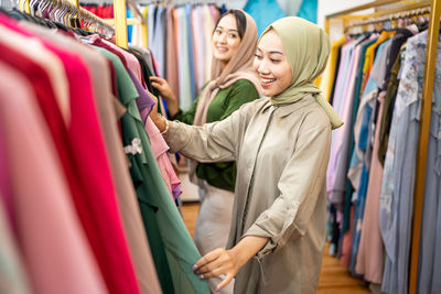 Smiling female friends shopping clothes