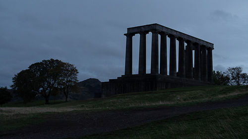 Low angle view of castle on field against sky at dusk