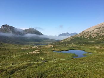 Scenic view of landscape and mountains against blue sky