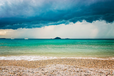 Cavo beach, ominous clouds foreboding a storm over the green sea - livorno, tuscany, italy 