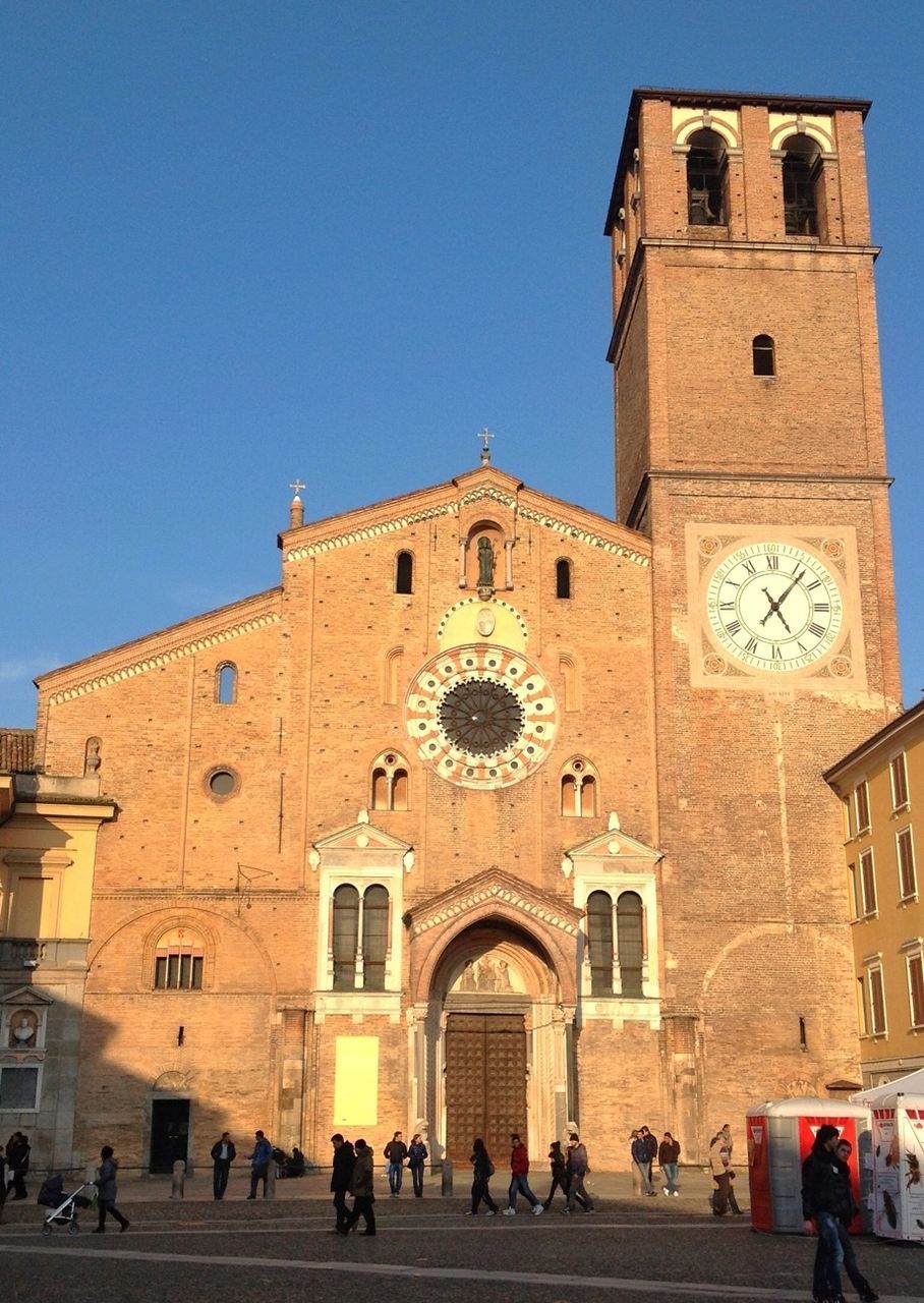 architecture, building exterior, built structure, place of worship, religion, church, clear sky, spirituality, facade, blue, low angle view, cathedral, history, travel destinations, arch, large group of people, famous place