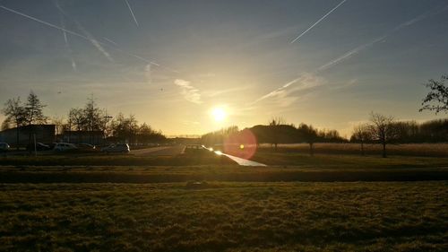 Scenic view of agricultural field against sky during sunset