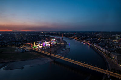 High angle view of illuminated buildings by river at night