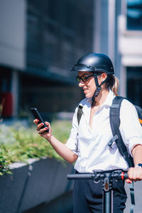 Young man using mobile phone in city