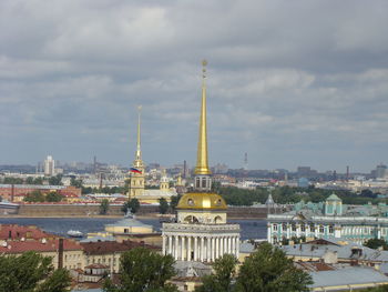 Buildings in city against cloudy sky