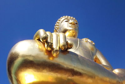 Low angle view of statue against blue sky