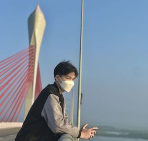 Portrait of young man standing against sea