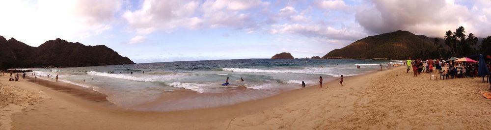 Scenic view of beach against cloudy sky