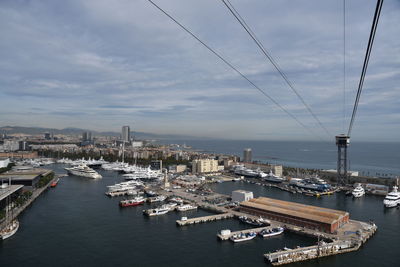 High angle view of harbor by cityscape against sky