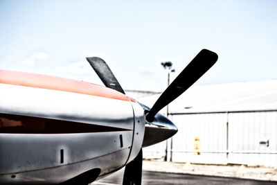 Airplane on airport runway against sky