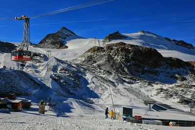 Scenic view of snowcapped mountains against blue sky