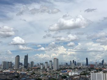 Aerial view of buildings in city against sky