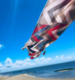 Low angle view of flags on beach against sky