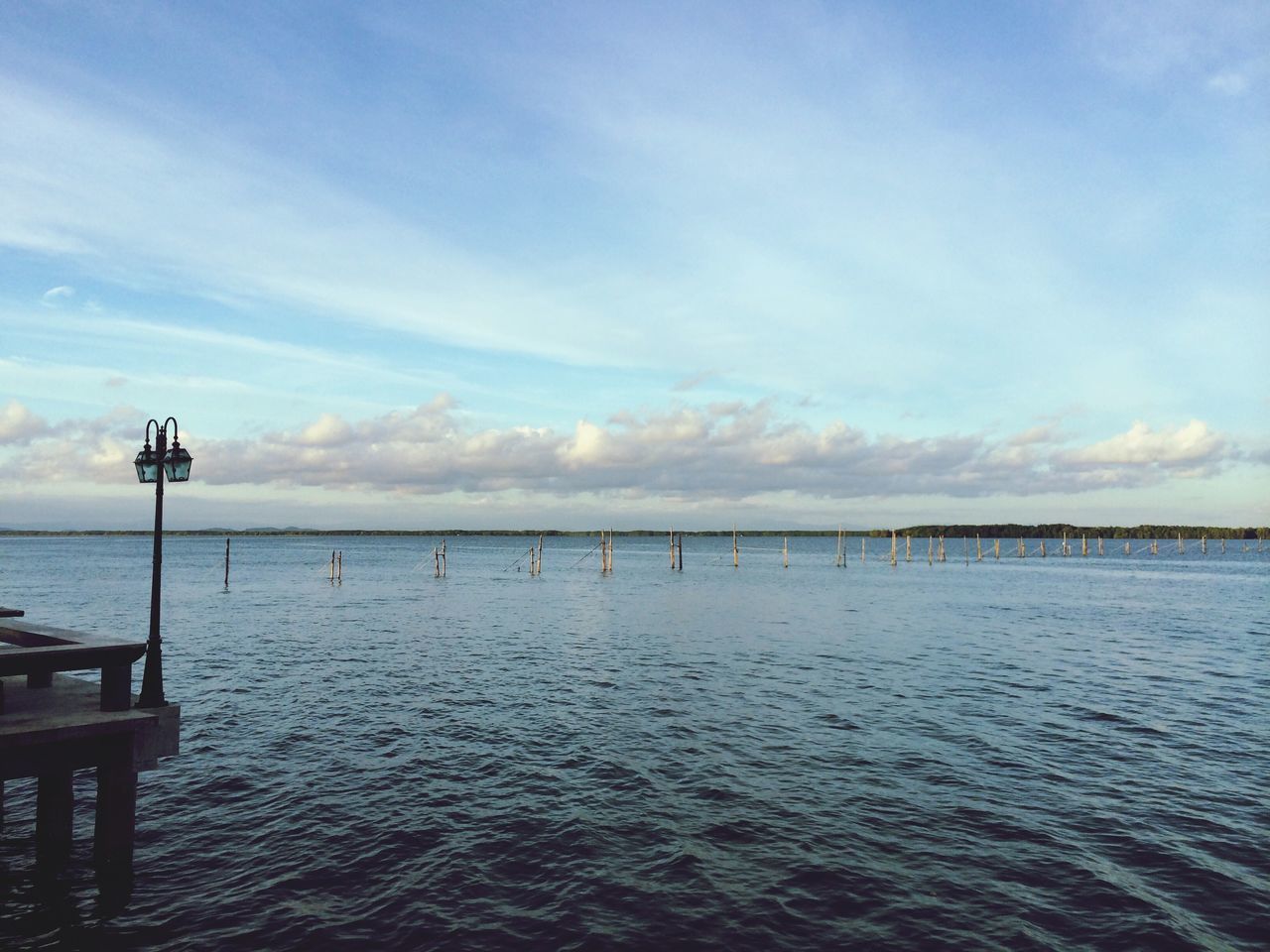 sea, water, sky, tranquil scene, tranquility, horizon over water, scenics, beauty in nature, nature, cloud - sky, cloud, idyllic, rippled, waterfront, calm, pier, outdoors, street light, remote, blue
