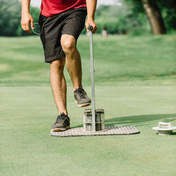 Low section of man standing on golf course