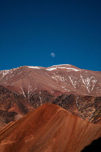 Scenic view of snowcapped mountains against clear blue sky