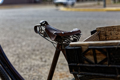 Close-up of empty bench on street in city