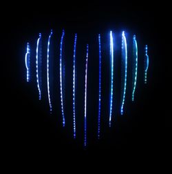 Close-up of illuminated lights over black background