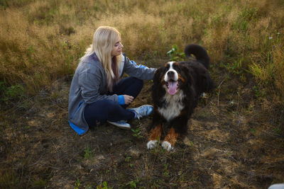 Full length of woman with dog on field