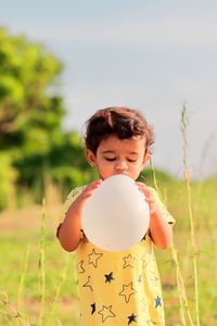 Portrait an indian boy pours air into the balloon