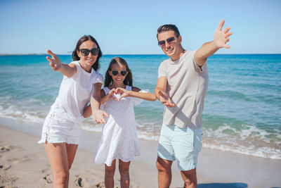 Happy friends standing at beach