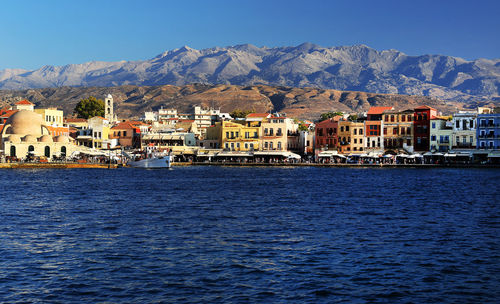 River with built structures against rocky mountains