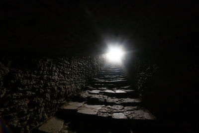 Footpath amidst illuminated lights at night