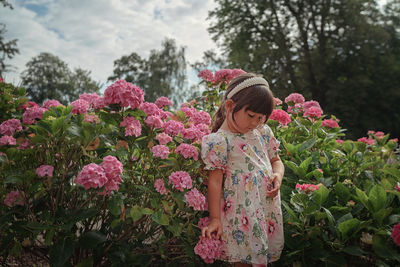 Girl standing on pink flowering plants