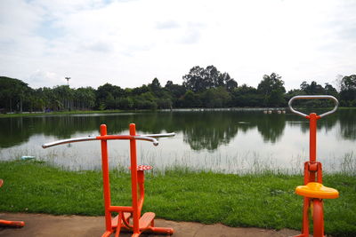 Gazebo in park by lake against sky