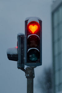 Close-up of traffic light against the sky