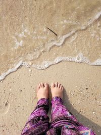 Low section of woman standing on beach