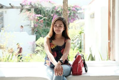 Portrait of young woman sitting outdoors