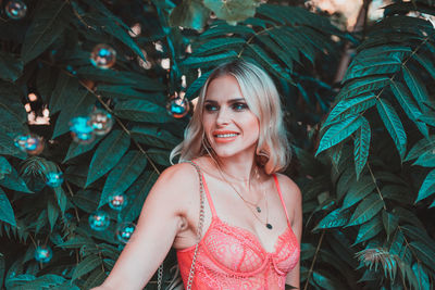 Smiling woman looking away while standing amidst bubbles