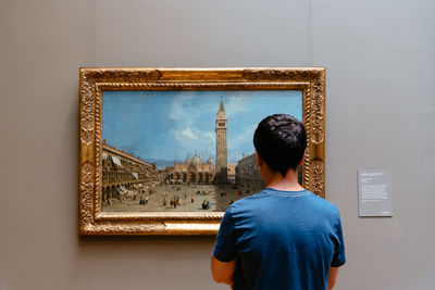 Rear view of man standing in front of museum