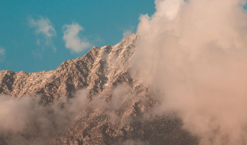 Low angle view of snow capped mountains against sky