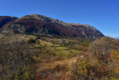 Scenic view of mountains against clear blue sky