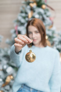 Portrait of young woman holding christmas decoration