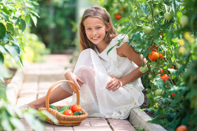 Portrait of young woman picking apples