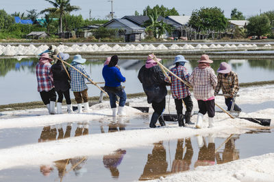 Farmers are using the tools to scoop the salt into a pile in salt garden at phetchaburi, thailand.