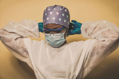 Doctor wearing mask against blue background