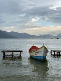 Boat moored in sea against sky
