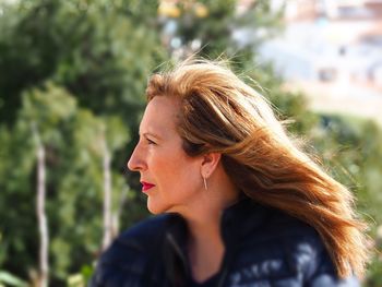 Close-up of young woman against trees