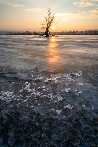 Scenic view of frozen sea against sky during sunset