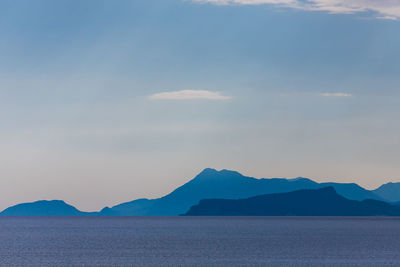 Scenic view of sea and mountains against sky