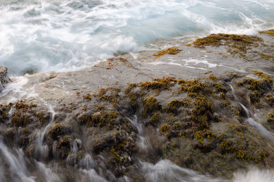 High angle view of waves breaking on rocks