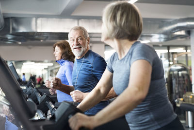 Group of fit seniors on treadmills working out in gym