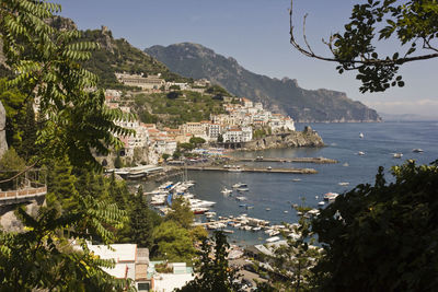 Scenic view of town by sea against sky