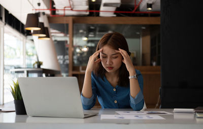 Exhausted businesswoman sitting in office